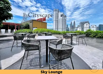 a group of tables and chairs on a patio with a city skyline at Majestic Residence Kuala Lumpur by Cityscape in Kuala Lumpur