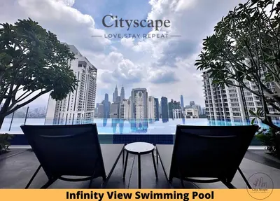 a balcony with two chairs and a view of a city at Majestic Residence Kuala Lumpur by Cityscape in Kuala Lumpur
