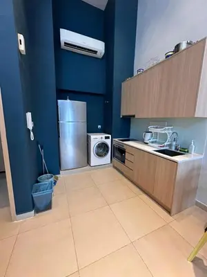 a blue kitchen with a washing machine and a washer at The Colony By Infinitum With Rooftop Pool in Kuala Lumpur