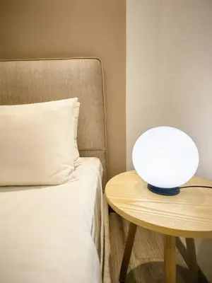 a lamp on a table next to a bed at TRX Agile Bukit Bintang Cozy 2 Bedroom and 1 Living Room Suites in Kuala Lumpur