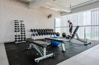 a man standing in a gym with weights at D'Majestic by Aspire Suites in Kuala Lumpur