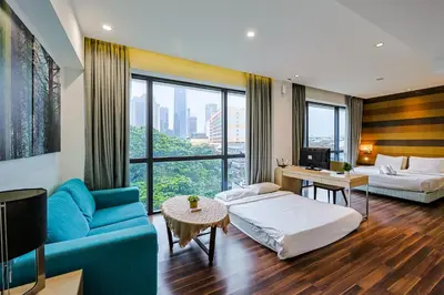 a hotel room with a blue couch and a bed at D'Majestic by Aspire Suites in Kuala Lumpur
