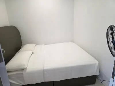 a small room with a bed with white sheets at Vortex suites klcc by KAZI in Kuala Lumpur