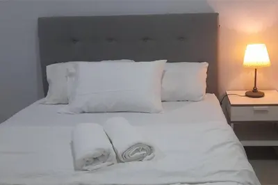 a bedroom with white towels on a white bed at Kuala Lumpur Mont Kiara Arcoris SOHO 5 Pax, Walk to Mall, Pool, WIFI in Kuala Lumpur