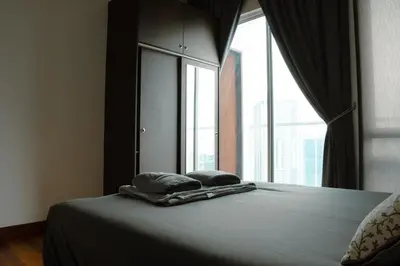 a bed with two pillows in front of a window at KL Luxury Residence 3BR Golden Triangle in Kuala Lumpur