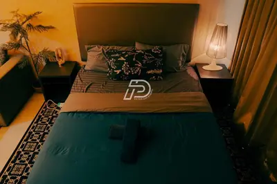 a bedroom with a large bed with a green comforter at Lux Studio Plaza Damas Kuala Lumpur KL in Kuala Lumpur