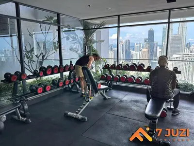 two people in a gym with a view of the city at KLCC 23A Premium 1B1R with Best View Infinity Pool and Netflix 1080HD in Kuala Lumpur