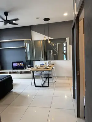 a living room with a table and a kitchen at ROBERTSON RESIDENCE KUALA LUMPUR By IKNAS SUITES in Kuala Lumpur