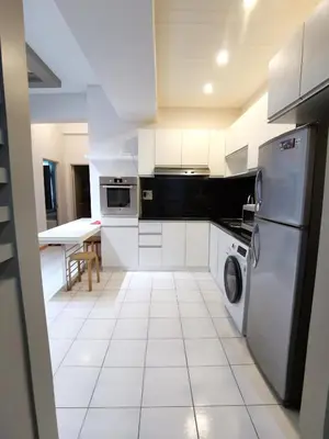 a kitchen with white appliances and a white tile floor at Seri Bukit Ceylon Kuala Lumpur in Kuala Lumpur
