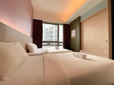 two beds in a hotel room with a window at Swiss Garden Residence by PILLOWTALKS in Kuala Lumpur