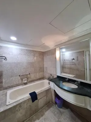 a bathroom with a tub and a sink and a mirror at Times Square Service Apartment , Kuala Lumpur in Kuala Lumpur