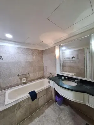 a bathroom with a tub and a sink and a mirror at Times Square Service Apartment , Kuala Lumpur in Kuala Lumpur