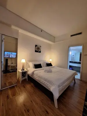 a bedroom with a large white bed and a television at Midtown Suite At Times Square Hotel KL in Kuala Lumpur