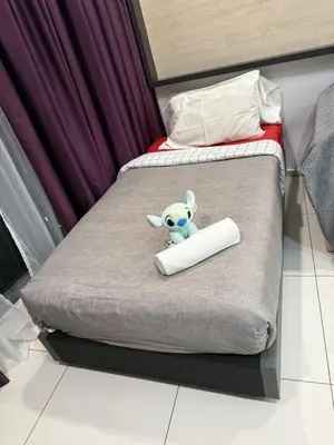 a stuffed animal sitting on top of a bed at PARKVIEW RESIDENCE KLCC By IKNAS SUITES in Kuala Lumpur