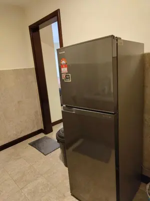a stainless steel refrigerator in a room with a doorway at BBS Suites At Times Square in Kuala Lumpur