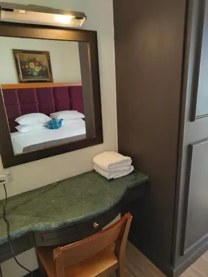 a bathroom with a vanity with a mirror and a bed at BBS Suites At Times Square in Kuala Lumpur