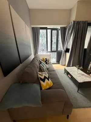 a living room with a brown couch in front of a window at Star Residences One KLCC in Kuala Lumpur