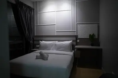 a bedroom with a white bed with a nightstand at Luxury Apartment - DATUM JELATEK - KLCC- LRT - MDMT - MALL - PARKING in Kampong Datok Keramat