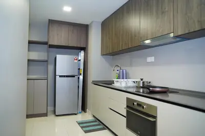 a kitchen with a refrigerator and a counter top at Luxury Apartment - DATUM JELATEK - KLCC- LRT - MDMT - MALL - PARKING in Kampong Datok Keramat