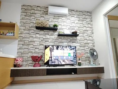 a living room with a tv on a brick wall at KL studio with Private Jacuzzi in Kuala Lumpur