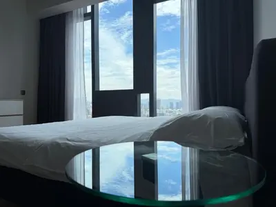 a bedroom with a glass table in front of a window at Star Residences One KLCC in Kuala Lumpur