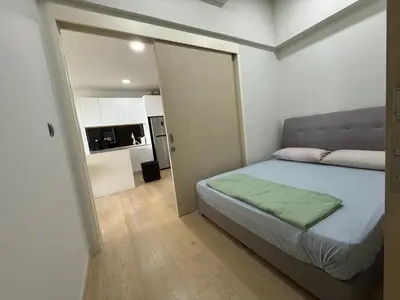 a bedroom with a bed and a door to a kitchen at Star Residences One KLCC in Kuala Lumpur