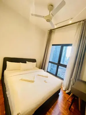 a bed in a room with a large window at KLCC Service Suites at Mews in Kuala Lumpur