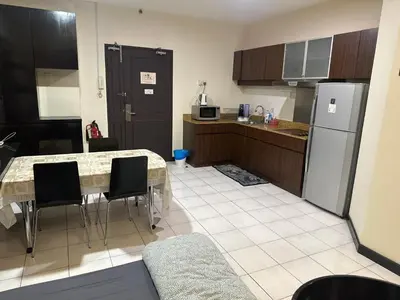 a kitchen with a table with chairs and a refrigerator at Bukit bintang central seri Bukit Ceylon in Kuala Lumpur