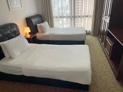 a hotel room with two beds and a window at City view Apartment at Times square in Kuala Lumpur