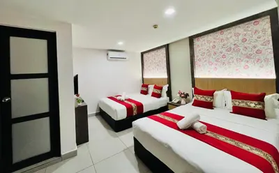 a hotel room with two beds and a door at Elite Hotel KL Sentral in Kuala Lumpur