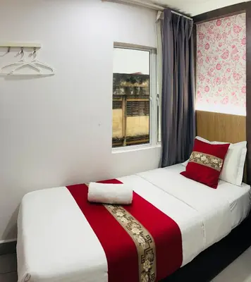 a bedroom with a bed with a red and white blanket at Elite Hotel KL Sentral in Kuala Lumpur