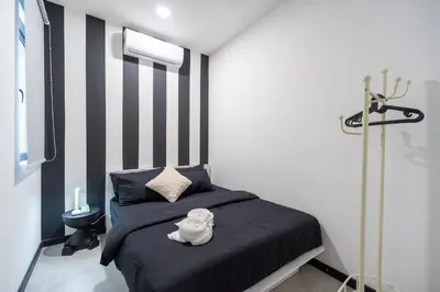 a bedroom with a bed with a black and white stripes at 2PAX-4PAX Projector Screen Stay near KLCC & Jelatek LRT Station in Kuala Lumpur