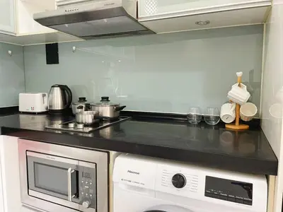 a kitchen with a stove top oven and a microwave at Casa Residency Apartment Bukit Bintang by Cupid home in Kuala Lumpur