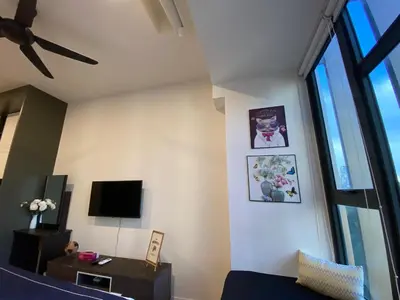 a living room with a couch and a tv at Ceylonz suites Klcc by StayLa in Kuala Lumpur
