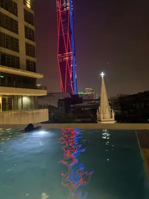 a reflection of a tower in a pool at night at Robertson Residence in Kuala Lumpur in Kuala Lumpur