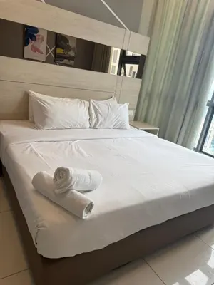 a bed with a rolled up towel on it at Robertson Residence in Kuala Lumpur in Kuala Lumpur