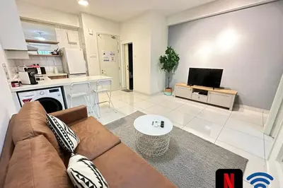 a living room with a couch and a kitchen at Cosy Place in Kuala Lumpur
