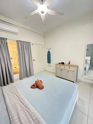 a bedroom with a large bed with a ceiling fan at Cosy Place in Kuala Lumpur