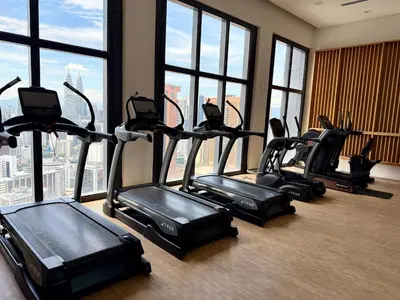 a group of treadmills in a gym with windows at Lucentia residence by lalaport in Kuala Lumpur