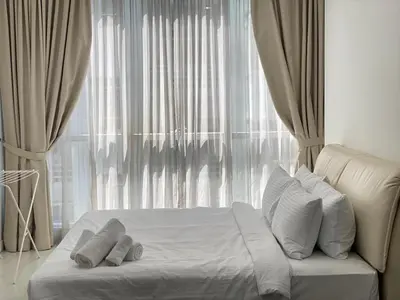 a white bed with pillows in front of a window at KLCC Bukit Bintang Binjai 8 premium soho by Prime Suites in Kuala Lumpur