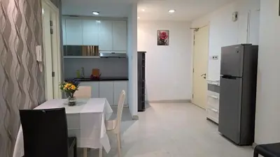 a kitchen with a table and a refrigerator at KLCC Bukit Bintang Binjai 8 premium soho by Prime Suites in Kuala Lumpur
