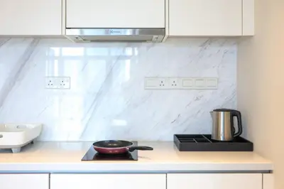 a kitchen counter with a frying pan on a stove at 8 min walk to Pavilion KL - Infinity Pool w TRX view in Kuala Lumpur