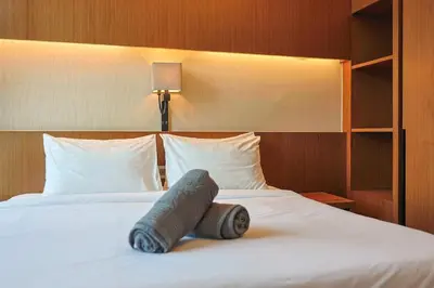a large bed in a hotel room with a pillow on it at 8 min walk to Pavilion KL - Infinity Pool w TRX view in Kuala Lumpur