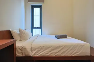 a bed with white sheets and a pillow on it at 8 min walk to Pavilion KL - Infinity Pool w TRX view in Kuala Lumpur