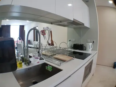 a kitchen with a sink and a dish drying rack at Soho Suites @ KLCC by Luxury Suites Asia in Kuala Lumpur