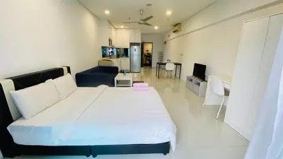 a bedroom with a large bed and a kitchen at Summer Suites KLCC BY Lotus in Kuala Lumpur