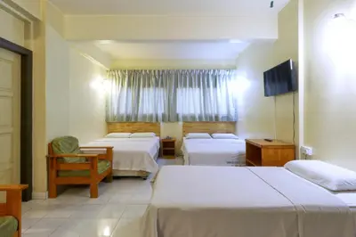 a hotel room with two beds and a tv at Nan Yeang Hotel Petaling Street in Kuala Lumpur