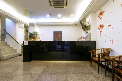 a waiting room with chairs and a counter and stairs at Nan Yeang Hotel Petaling Street in Kuala Lumpur