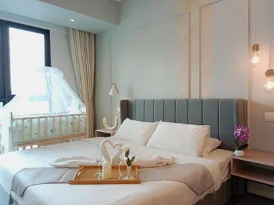 a bedroom with a bed with a tray with flowers on it at Ooak Suites Mont Kiara Mall 163 Babycot 4 Pax in Kuala Lumpur