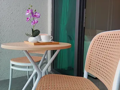 a table with two cups and a flower on it at Ooak Suites Mont Kiara Mall 163 Babycot 4 Pax in Kuala Lumpur